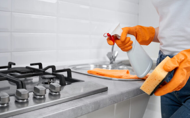 Woman holding rag and detergent for cleaning cooker. house cleaning Edmonton